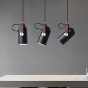 Three black cylindrical pendant lights with brown leather straps and brass accents from decorbites led hanging lamp collection