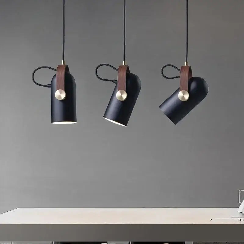 Three black cylindrical pendant lights with brown leather straps and brass accents from decorbites led hanging lamp collection