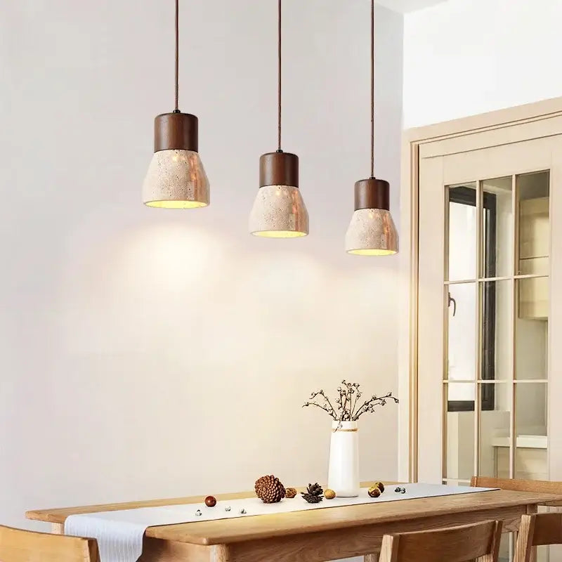 Decorbites led hanging lamps feature three yellow travertine pendant lights with matte bronze tops above a wooden table