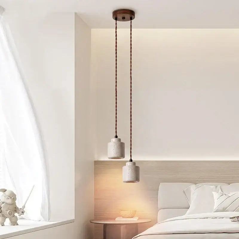 Two cylindrical yellow travertine pendant lights with dark cords hang from a wooden decorbites led hanging fixture