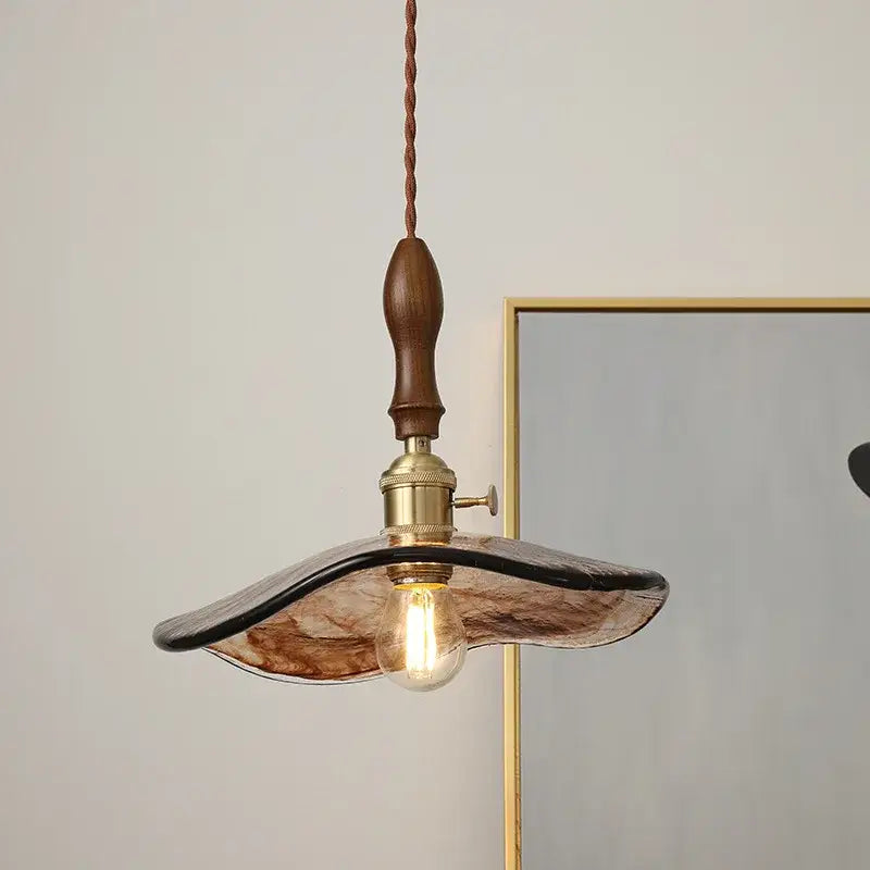 Decorbites led hanging light featuring warm-toned hand-blown glass with wooden handle and brass fittings for modern interiors