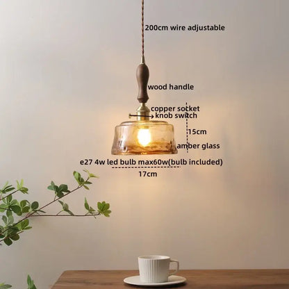 A warm amber glass decorbites led hanging light with wooden handle copper socket and adjustable 200cm wire