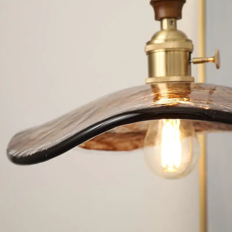 A warm-toned decorbites led hanging light pendant lamp with textured amber black glass and brass hardware for living rooms