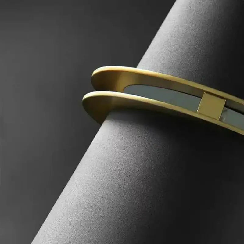Gold-toned bangle with sleek modern design alongside decorbites led horn wall lamp for bedside home decor