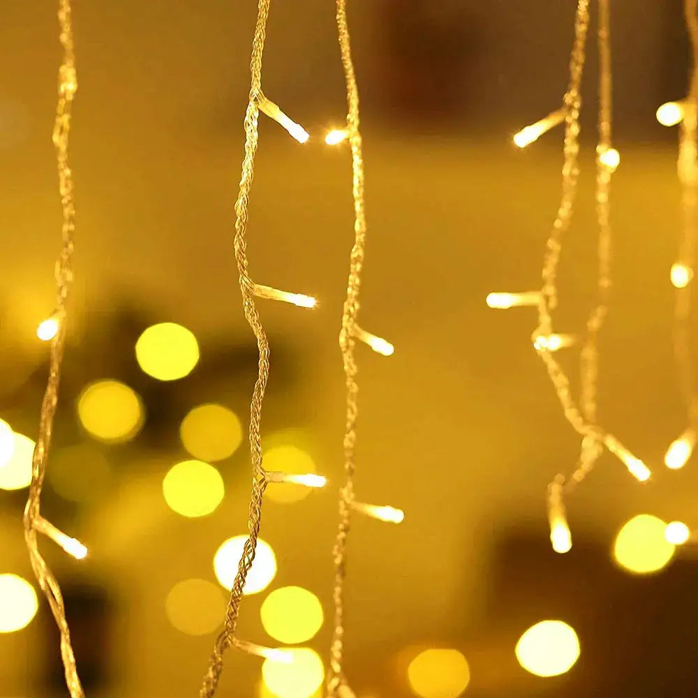 Golden warm glowing led icicle string lights by decorbites for outdoor holiday decor with delicate hanging strands