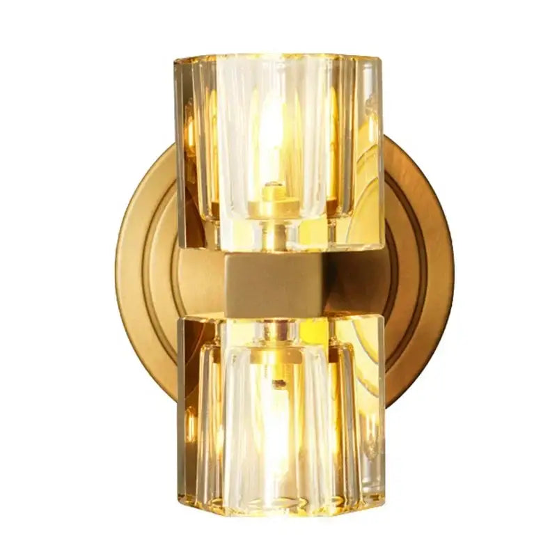 Gold-finished decorbites led indoor bedside lamp with two faceted glass cylinders emitting warm glow for modern spaces