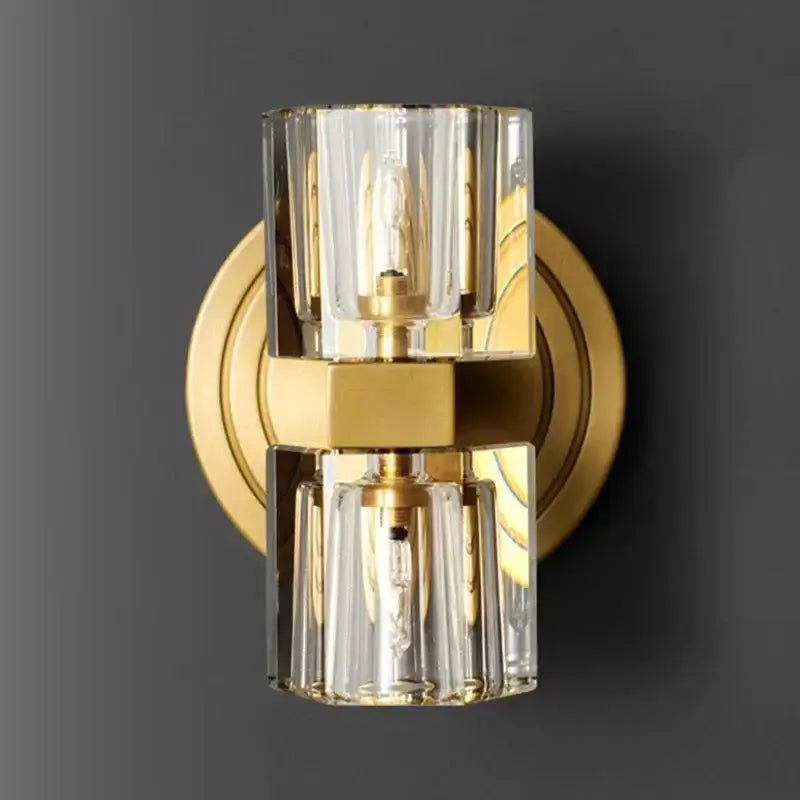 Gold-toned decorbites led indoor bedside lamp with two clear faceted glass cylinders housing exposed bulbs