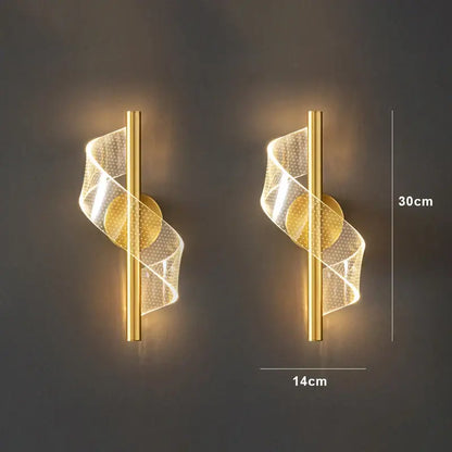 Gold-finished decorbites™ wall sconce light with spiraling translucent mesh emitting warm light for indoor decoration