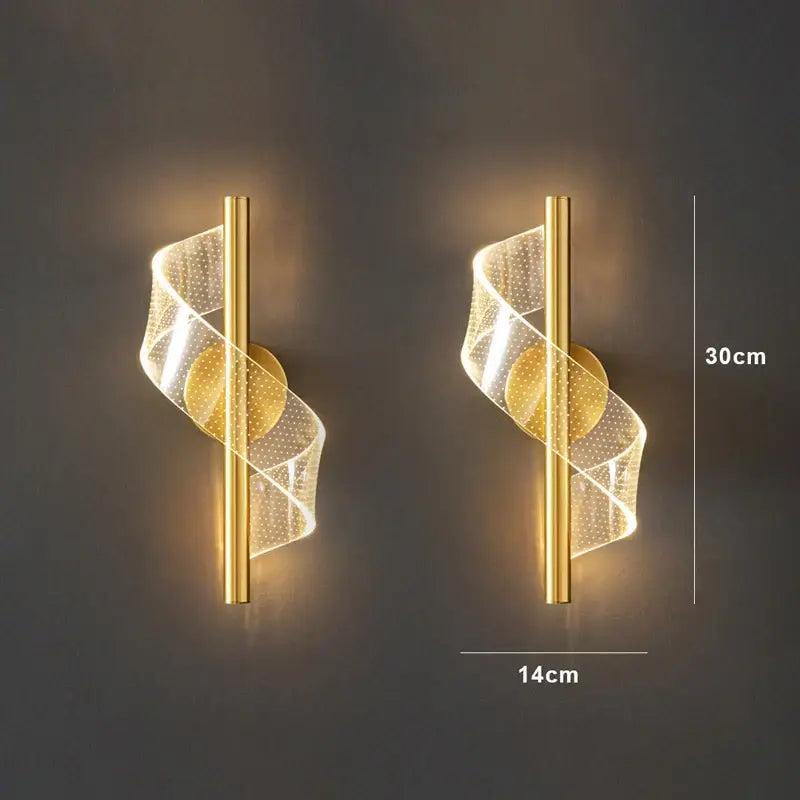 Gold-finished decorbites™ wall sconce light with spiraling translucent mesh emitting warm light for indoor decoration