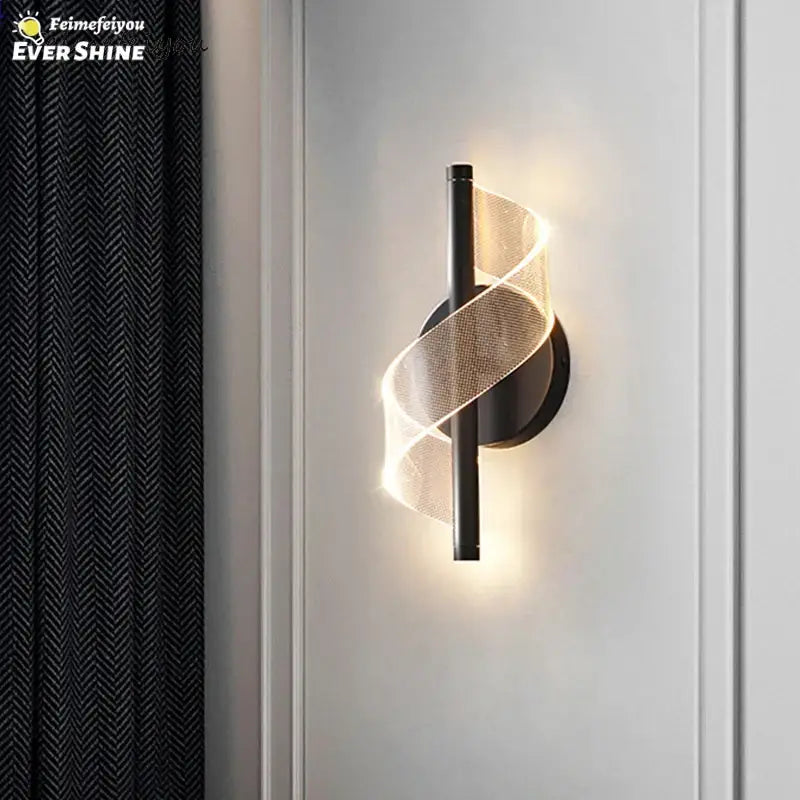 Modern black metal wall sconce light with glowing translucent spiral mesh design for indoor bedroom and living room use