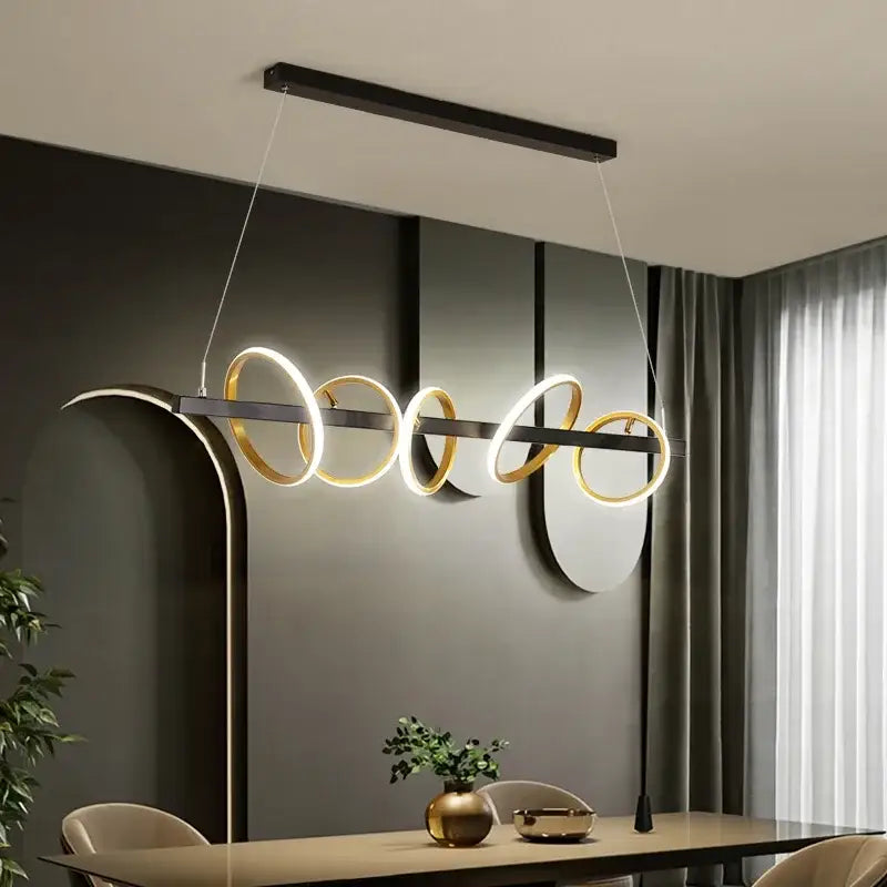 Modern black and gold decorbites led industrial chandelier with glowing circular rings above a dining table