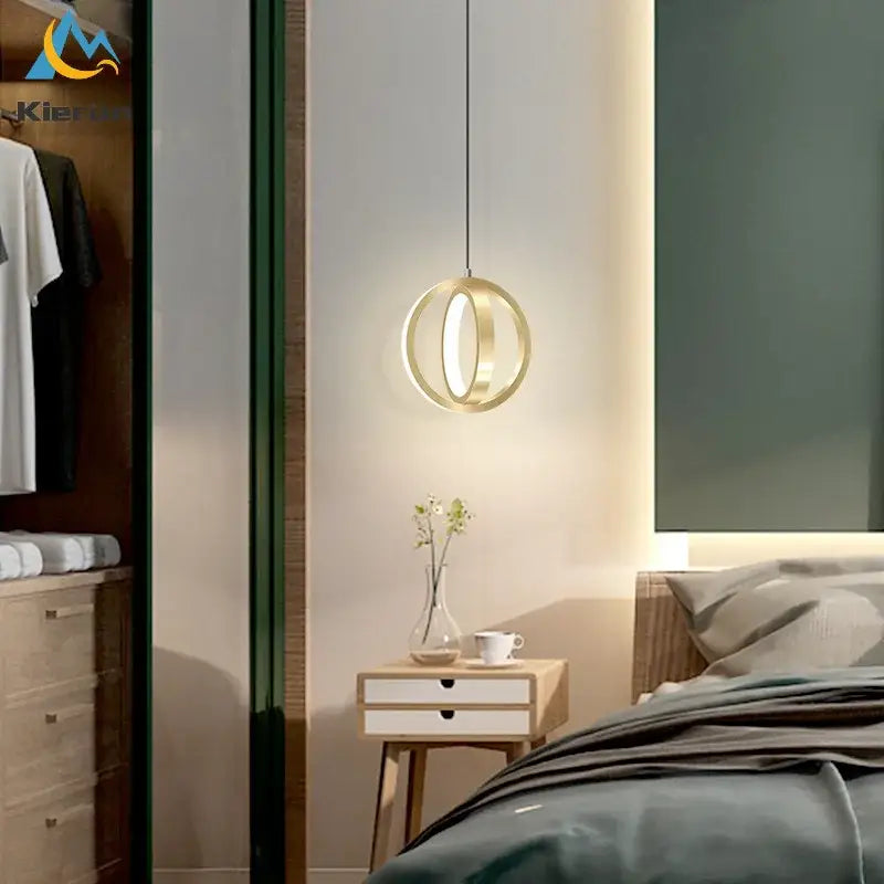 Gold-toned circular decorbites led iron art small chandelier with minimalist design hanging above bedside table