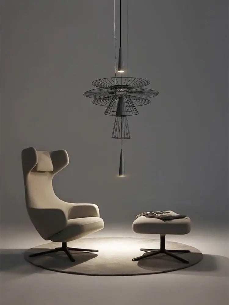 Cream-colored upholstered wingback armchair with black metal base shown with decorbites led iron pendant chandelier