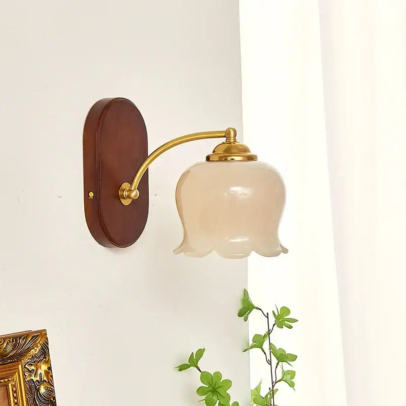 A delicate blush glass brass decorbites led japanese style wall light mounted on dark wood for bedroom decor