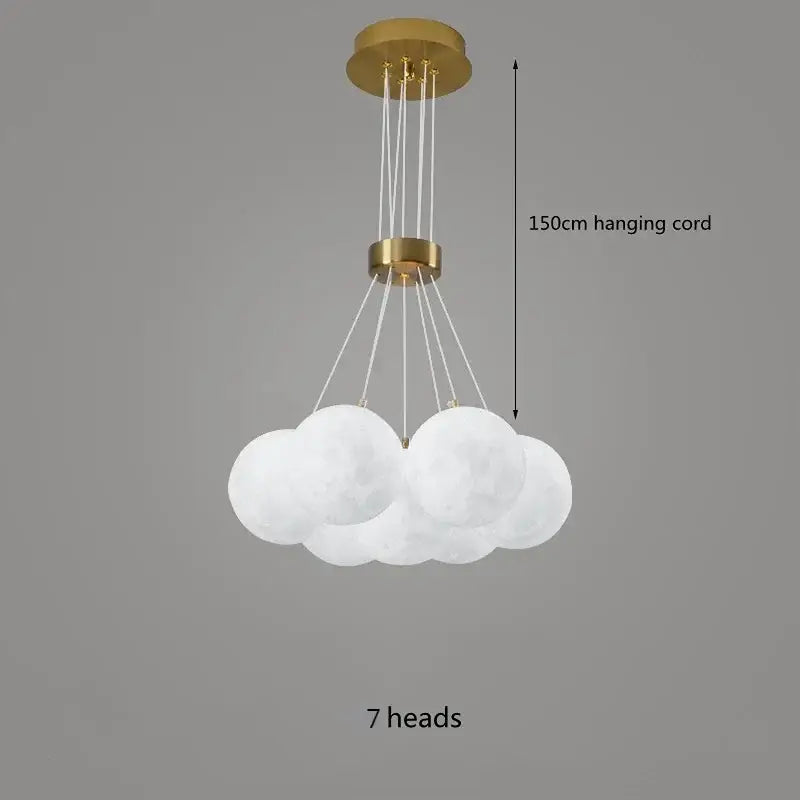 A modern decorbites led lunar cloud-shaped pendant light with seven frosted white spheres and gold metal cord for home decor