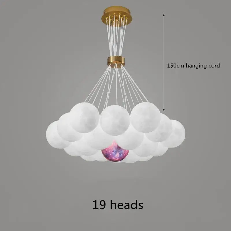 A decorbites led lunar ball chandelier with 19 frosted white spheres and a glowing cosmic orb suspended by gold hardware