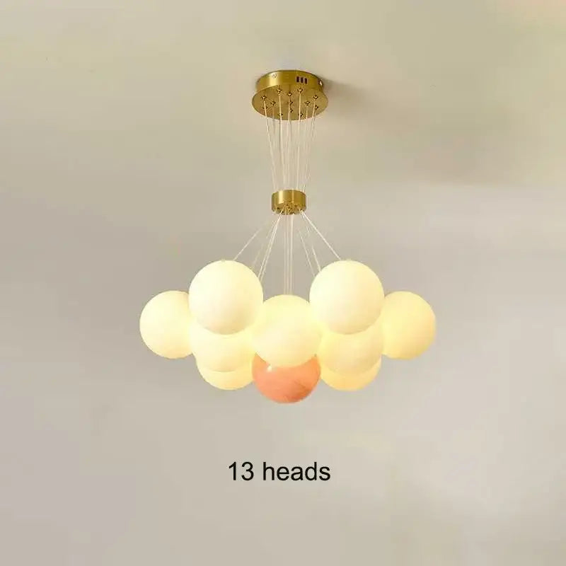 A modern decorbites led lunar chandelier with gold finish and 13 soft white cream and peach glass bulbs for home lighting