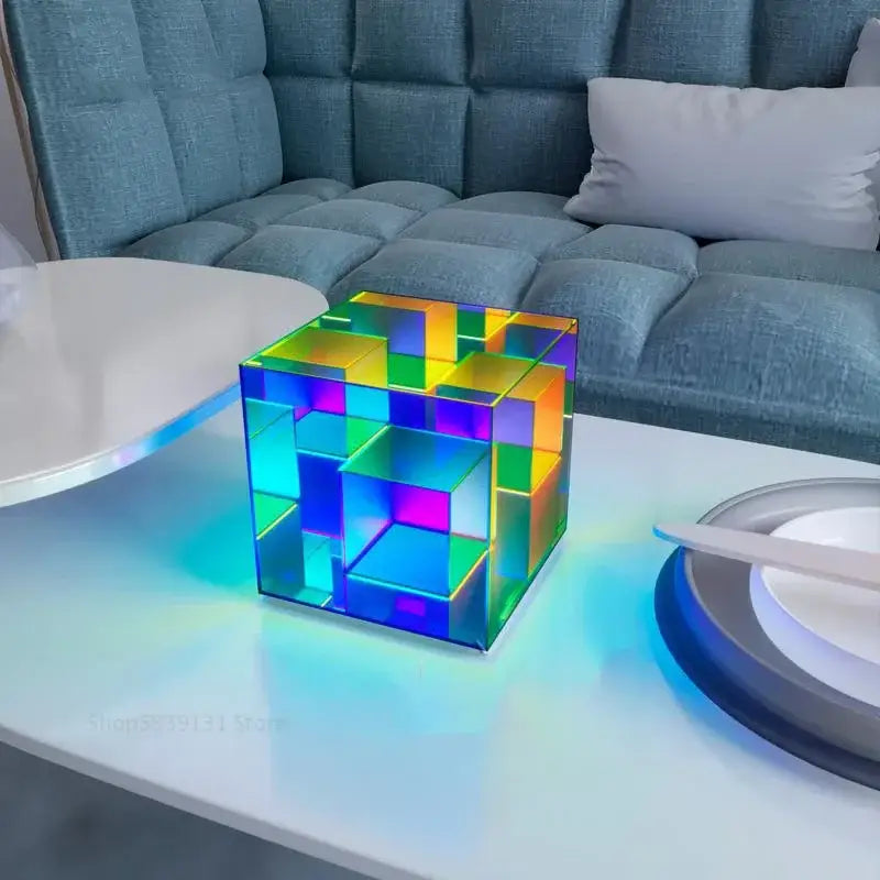 A translucent rainbow-colored geometric led magic cube desk lamp from decorbites led magic on a white table