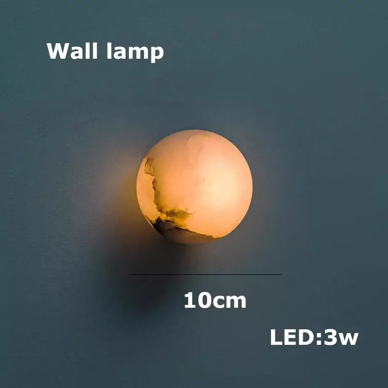 A warm glowing spherical decorbites led marble wall lamp with textured surface for dining room chandelier use