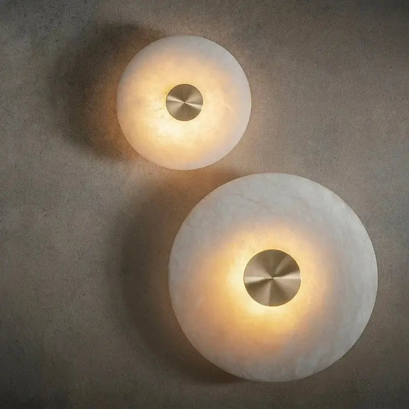 Two minimalist wall sconces with frosted glass domes and brushed metal centers from decorbites led marble brass collection