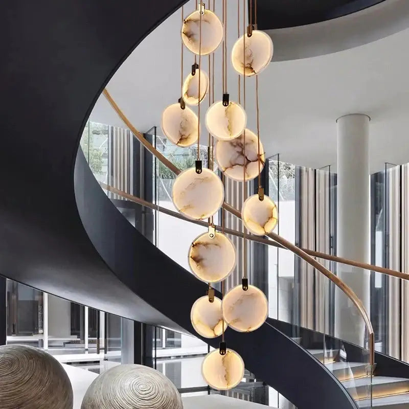 A modern decorbites led marble pendant lamp with warm-toned marble orbs and brass chains for living room lighting