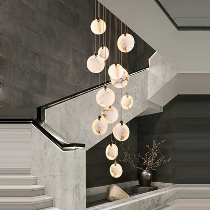 A decorbites led marble gold chandelier with spherical translucent marble-like shades suspended by thin metallic chains