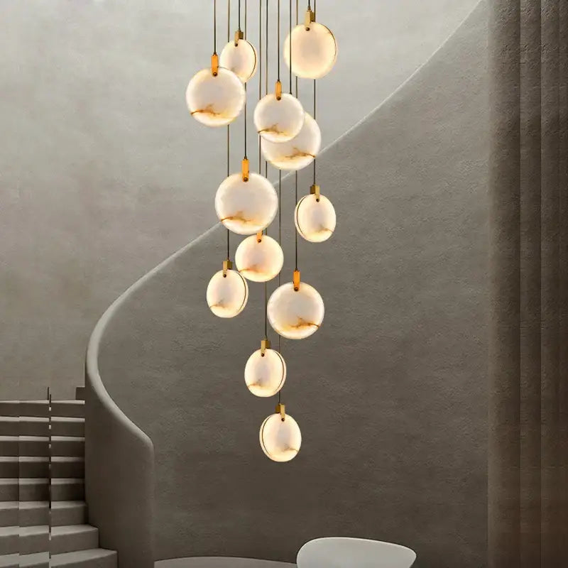 A modern decorbites led marble gold chandelier with spherical white glass orbs and gold-toned fixtures for living room