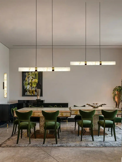Emerald green velvet dining chairs with dark wooden frames complement DecorBites™ led marble hanging lamps white alabaster