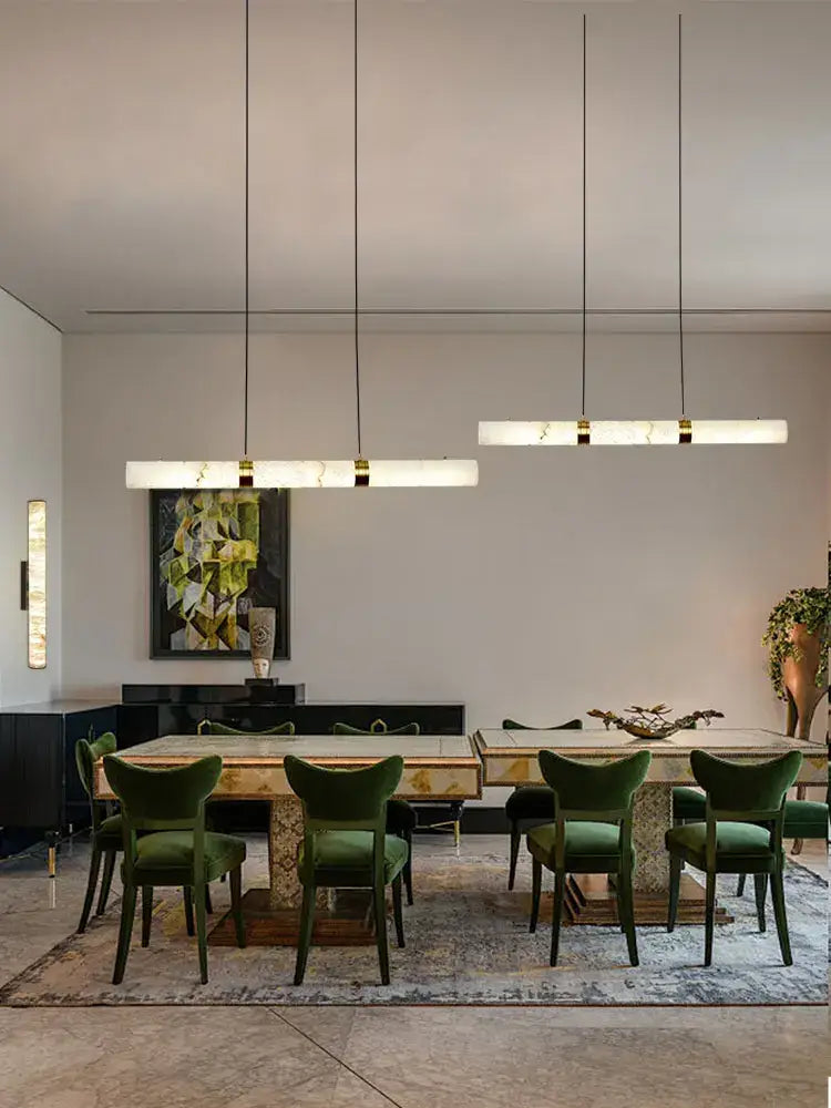Emerald green velvet dining chairs with dark wooden frames complement DecorBites™ LED marble hanging lamps white alabaster