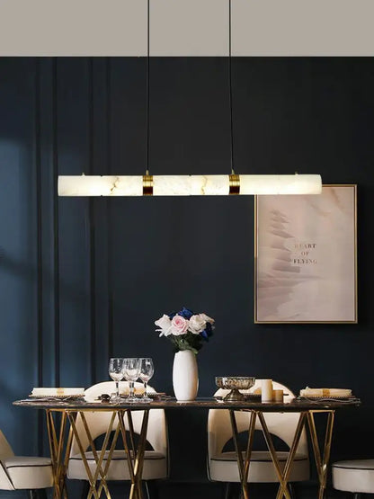 Decorbites™ led marble hanging lamps feature a sleek white alabaster finish with gold accents above a dining table
