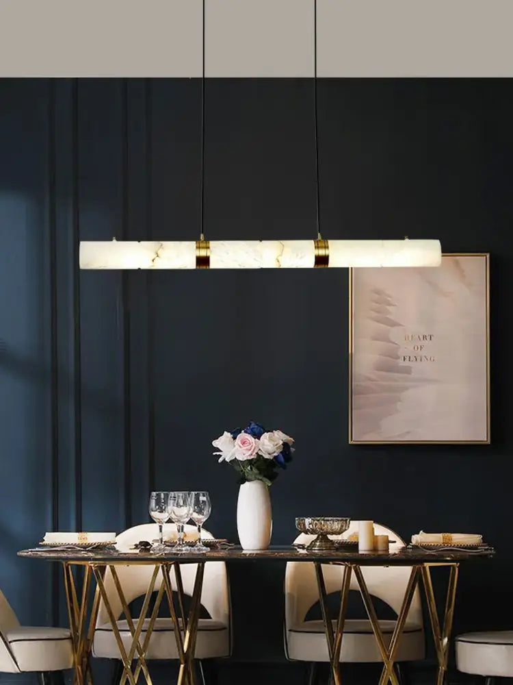 Decorbites™ led marble hanging lamps feature a sleek white alabaster finish with gold accents above a dining table
