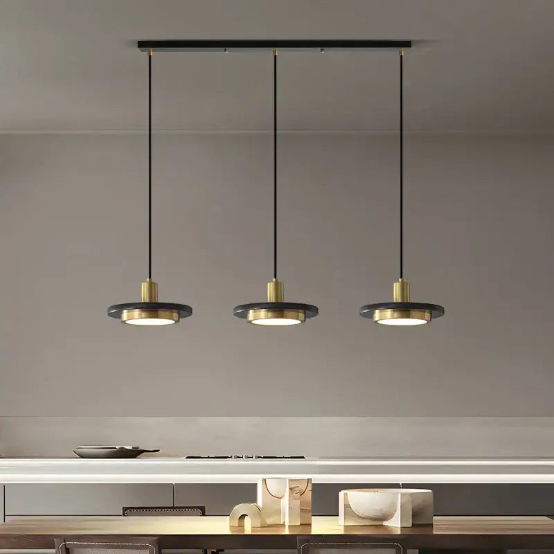 Modern black and brass decorbites led marble pendant lamp with circular shades hanging from a sleek bar