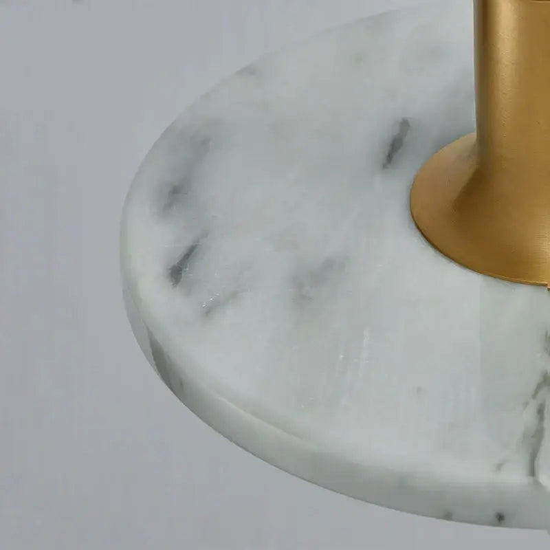 White marble table base with subtle gray veining and polished gold-toned metal pedestal for DecorBites LED marble pendant light