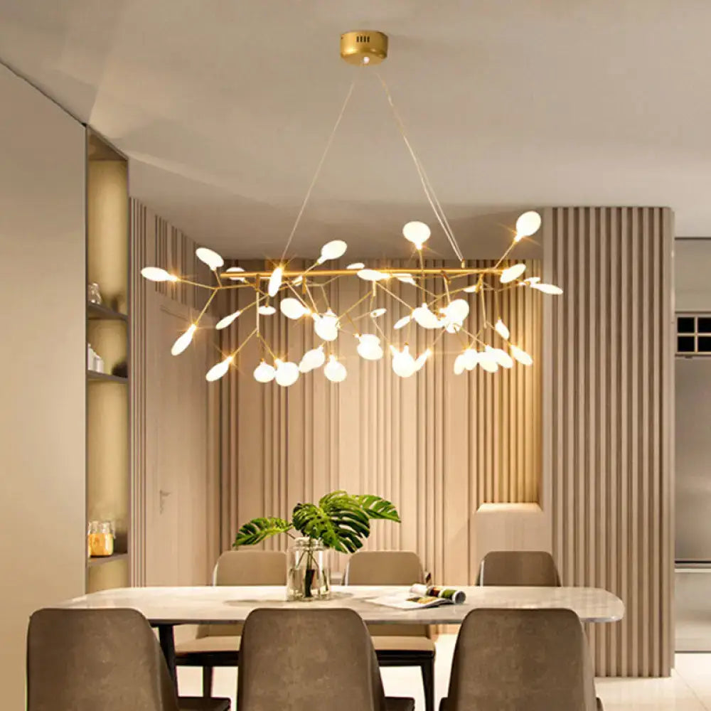 Gold-toned metallic ceiling light with tree branch design and frosted glass globes for minimalist dining room use