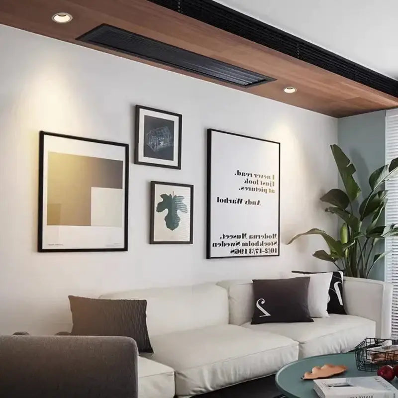 White upholstered sofa with dark brown and black pillows illuminated by decorbites led mini ceiling downlights for cabinets