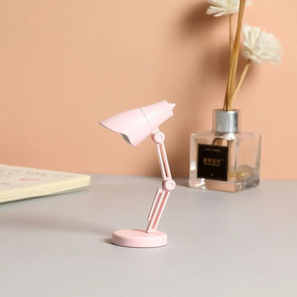 A delicate pink decorbites led mini desk lamp with a foldable arm and magnetic base for bedroom and study use