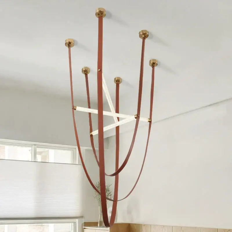 A modern decorbites led minimalist pendant lamp with brown leather straps and polished brass fittings for living room decor