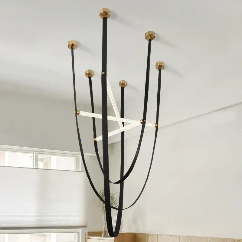 Black leather straps with gold metal caps form a decorbites led minimalist pendant lamp led minimalist chandelier