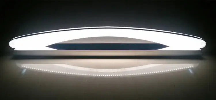 Modern white DecorBites LED mirror light fixture with sleek curved design and central dark accent strip for makeup bathrooms
