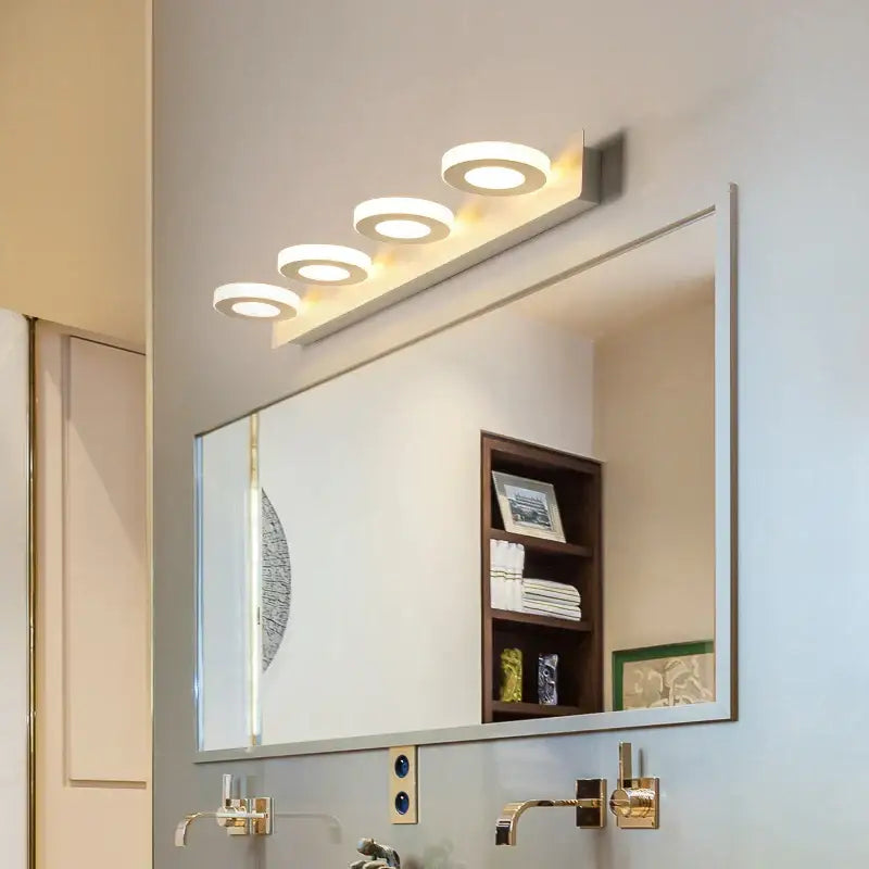 Modern white DecorBites LED mirror light with four circular acrylic bulbs mounted above a bathroom mirror