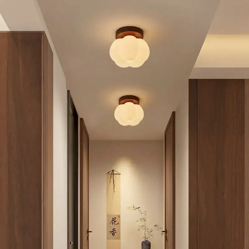 Two warm-toned cloud-shaped ceiling lights with wooden bases illuminate a hallway decorbites led modern ceiling light