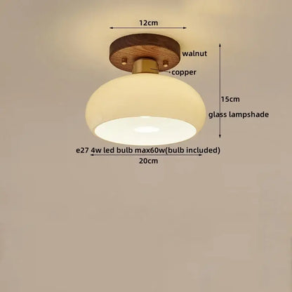Rounded glass lampshade with warm glow on walnut base and copper hardware in decorbites led modern ceiling light