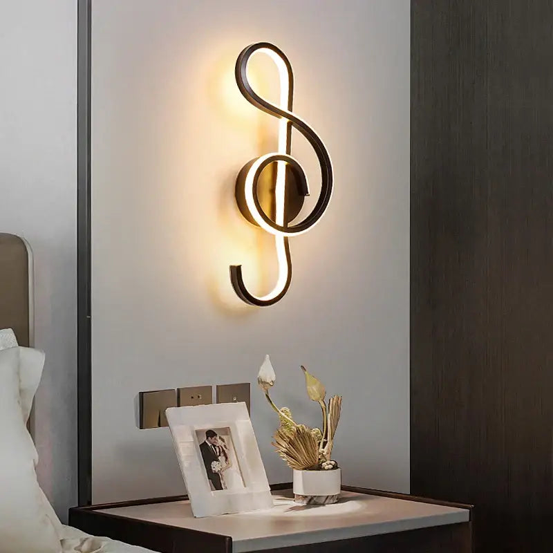 A sleek decorbites led modern wall lamp shaped like a gold-toned treble clef with integrated led lighting