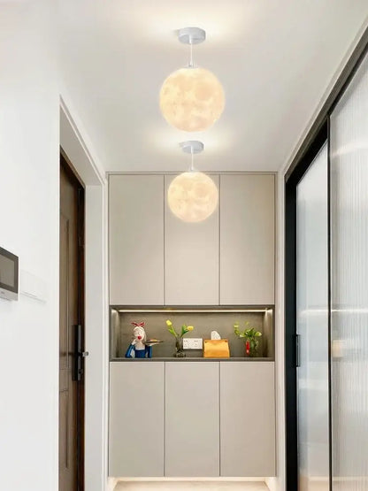 Two warm glowing spherical pendant lights from the decorbites led moon planet ceiling chandelier for home decor