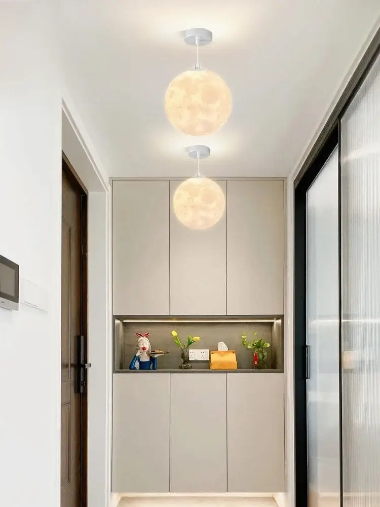 Two warm glowing spherical pendant lights from the decorbites led moon planet ceiling chandelier for home decor