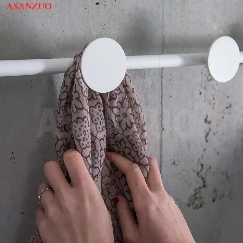 White circular hook holding a mauve scarf with brown floral patterns beside DecorBites led moon wall lamp