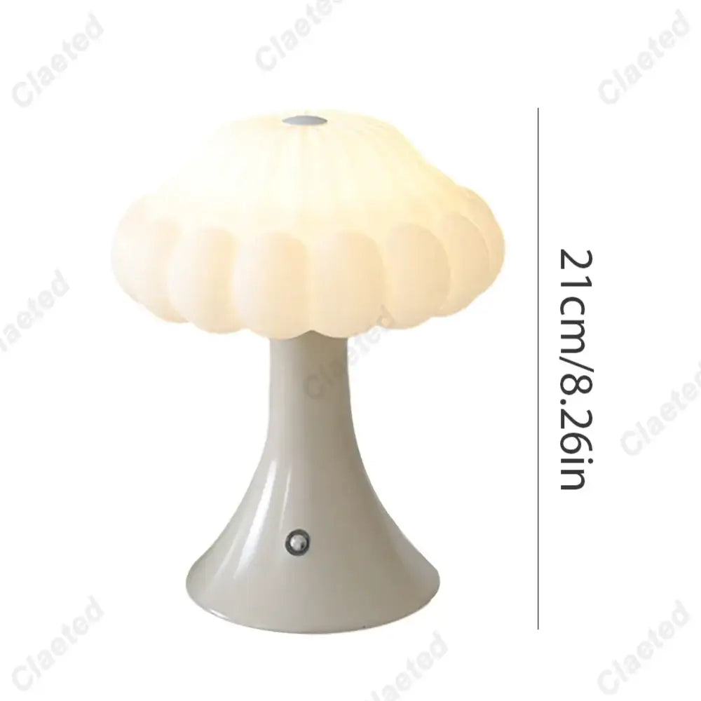 A cream-colored decorbites led mushroom night light with a glossy base and petal-like shade for kid’s room decor