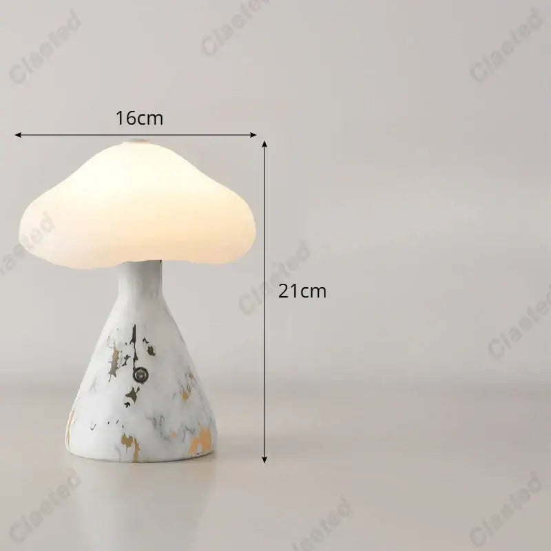 A white and gold marble-patterned decorbites led mushroom night light with a glowing translucent cap for bedside use