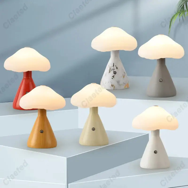 A collection of DecorBites led mushroom night light lamps in red plastic, wood-toned resin, gray ceramic, and cream marble