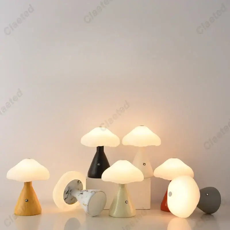 A collection of decorbites led mushroom night lights in matte black, white marble, pastel green, wood, and solid gray